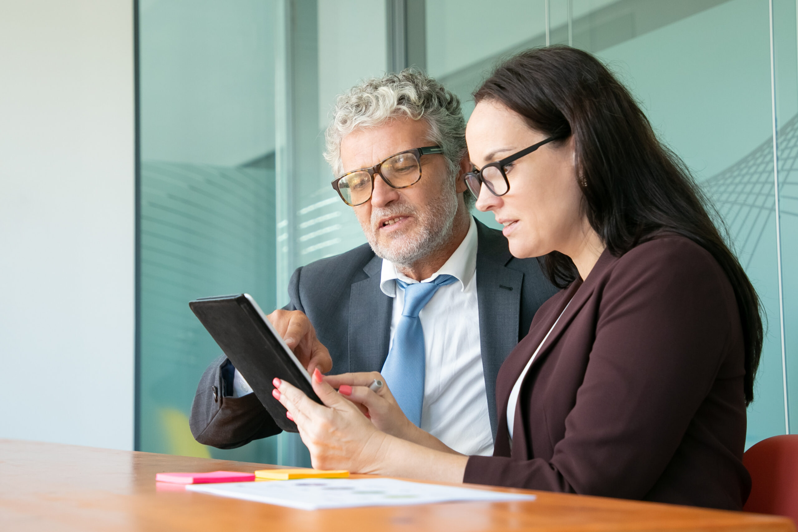 male and female colleagues using tablet together
